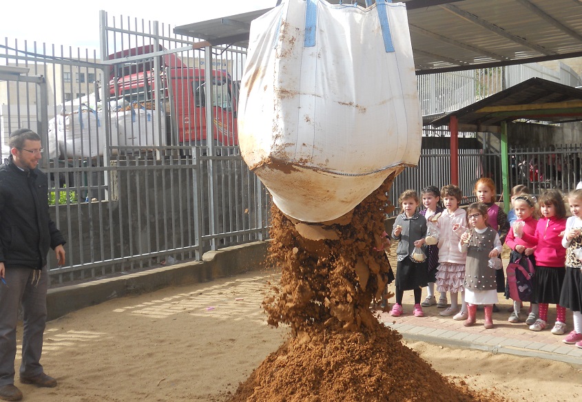 Leshomra's founder Avishai Himelfarb supervising a delivery of soil to a Modiin Illit kindergarten